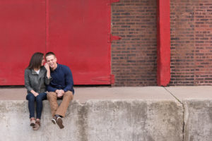 abby and Andrew in front of red door during Chicago engagement sessin