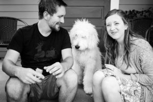 couples poses with their dog