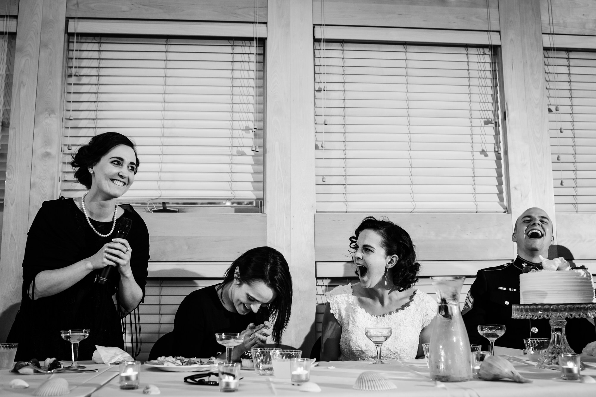 bride and groom laughing during maid of honor speech