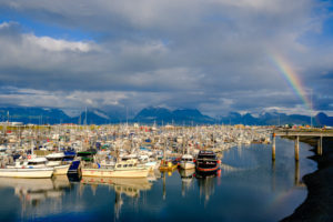 sunset and rainbow in the homer, alaska boat harbor