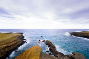woman on cliff at green sands beach on the big island of Hawaii
