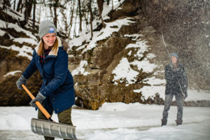Woman shoveling snow for ice hockey at pewits nest in baraboo