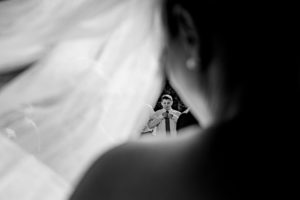 black and white candid shot of ring bearer through bride's veil in door county Wisconsin