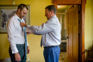 Groom getting help putting on his first tie