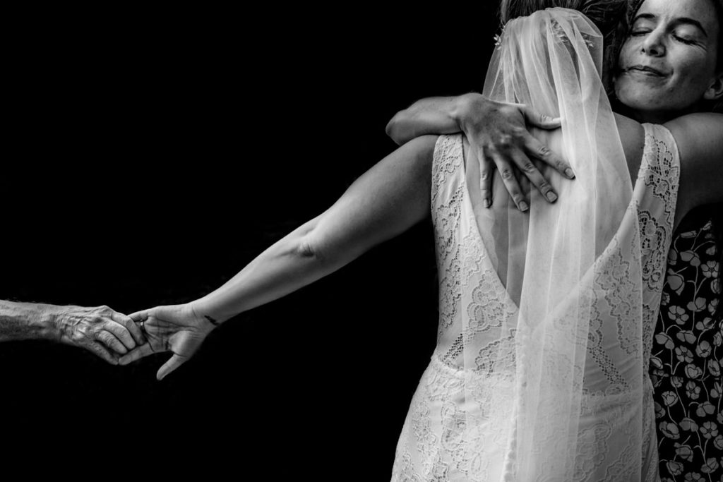 grandma holds onto the bride's hand after a wedding ceremony