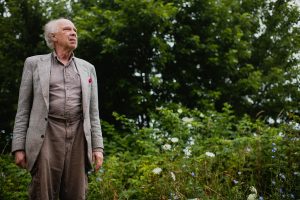 Uncle stands in field of plants in Wisconsin