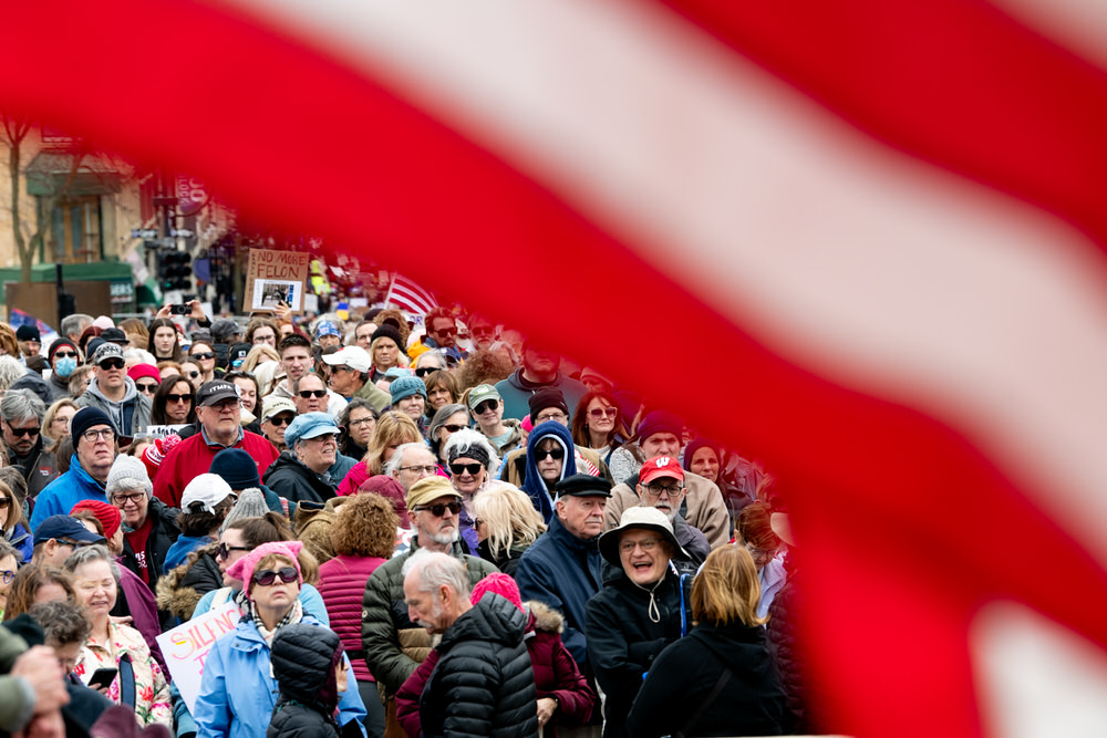 Attendees listen to a speaker from the Capitol steps during the Hands Off! rally on the Capitol Square in Madison, Wis., on Saturday, April 5, 2025.