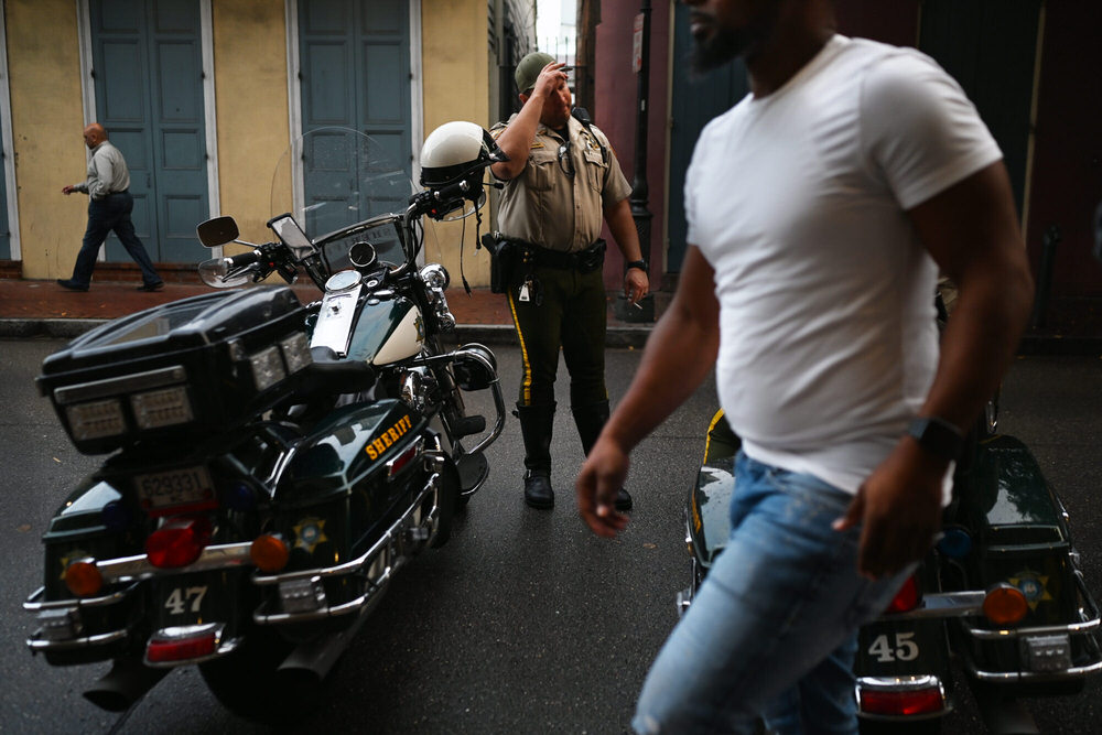 A person walks past a cop between two motorcycles for cops.