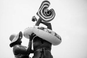 One friend helps the other get out of their stuck inter tube.