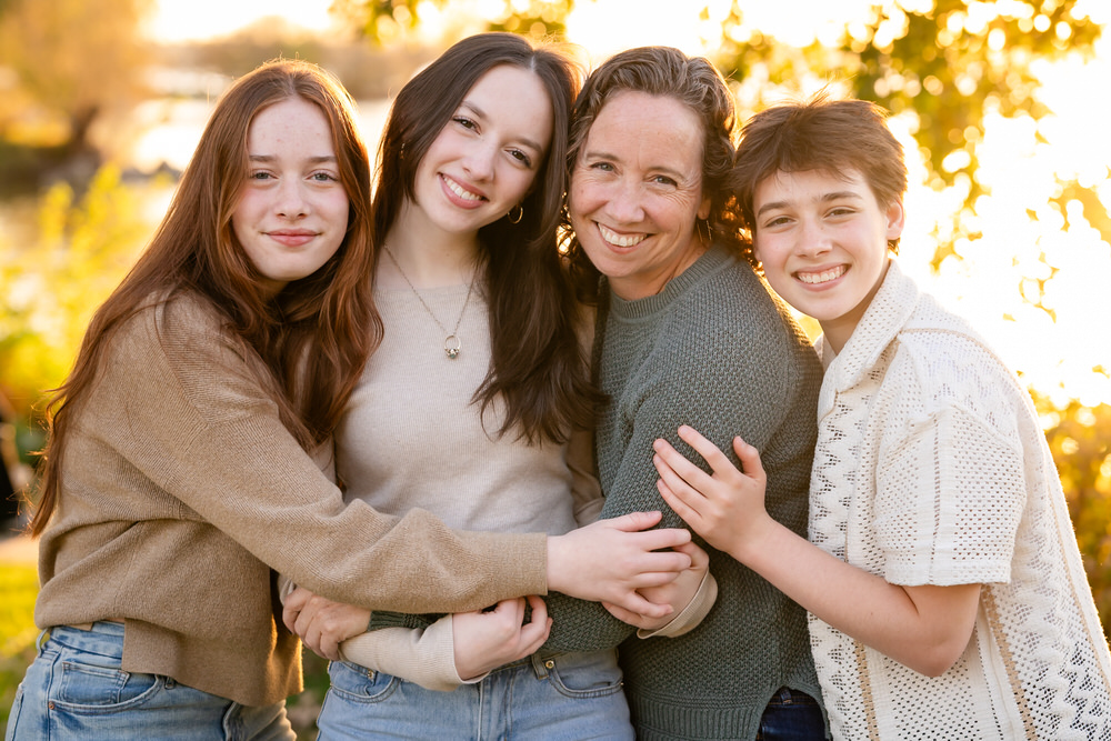 Maddy+Kids+Madison Family session at Tenney Park during golden hour, with three children and an adult hugging and smiling.
